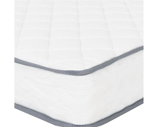 A close-up of a white quilted mattress corner, showing a gray patterned trim along the edge.