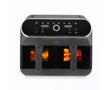A dark gray multi-compartment air fryer with a glossy black digital control panel and glowing orange food inside three cooking baskets, shown on a white background.