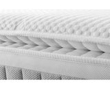 Close-up of a white mattress showing its quilted top surface, layered mattress core, and breathable mesh side panel.