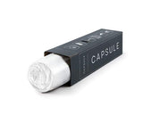 A black capsule packaging box with a white rolled capsule partially pulled out, shown on a clean white background.