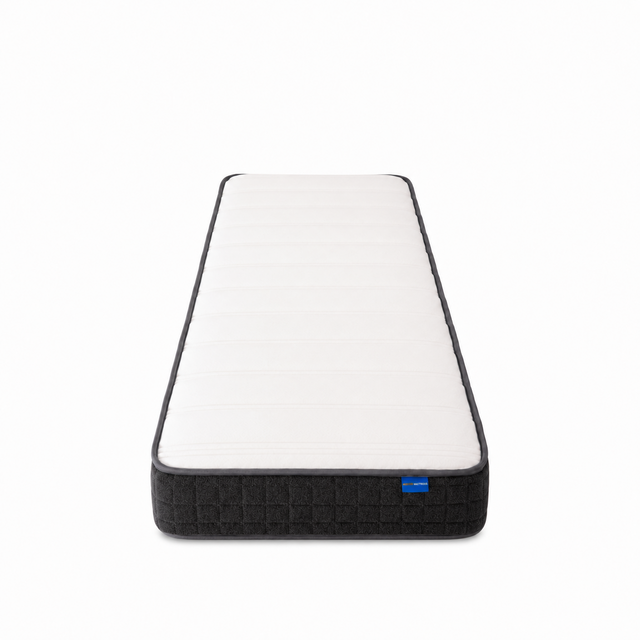 A single mattress shown from a top-down perspective on a clean white background. The mattress features a white quilted top surface with a dark gray or black textured base and a small blue brand tag on the right side.