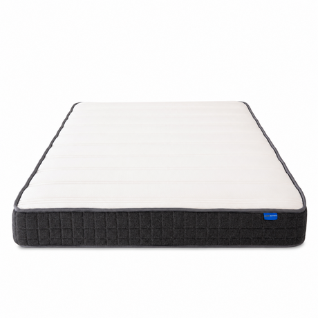 A mattress shown from a top-down angle on a clean white background. The mattress features a white quilted top surface and a dark charcoal gray textured side panel with a small blue brand tag.