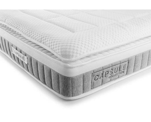 A white and gray mattress shown at an angle on a clean white background, with the brand name CAPSULE COLLECTION visible on the side label.