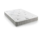 A white tufted mattress with a gray ribbed side border, shown at an angle on a clean white background.
