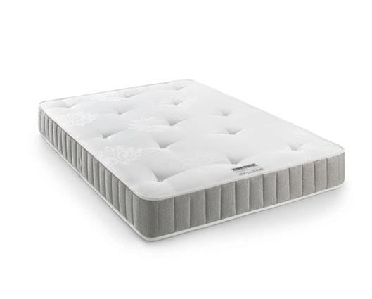 A white tufted mattress with a gray ribbed side border, shown at an angle on a clean white background.